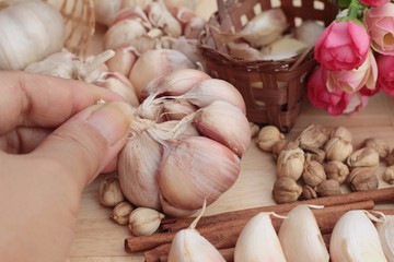 Garlic  has health benefits on wood background.