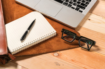 Business workplace from top smart watch, smart phone, glasses, laptop on wooden desk
