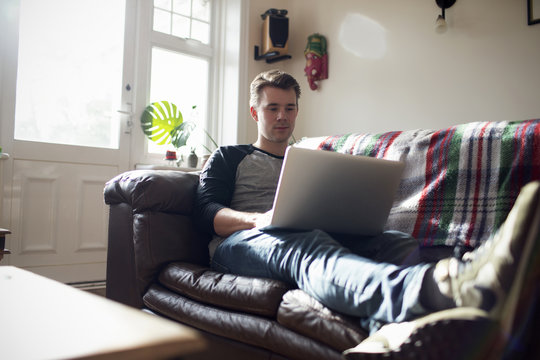 Young Man Using Laptop At Home
