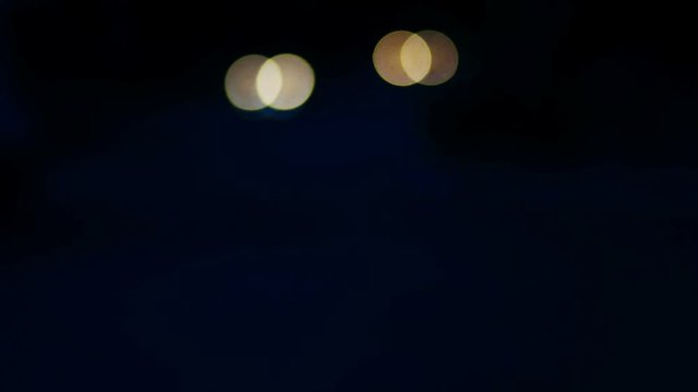 Defocused night traffic lights, sparce lights in the dark