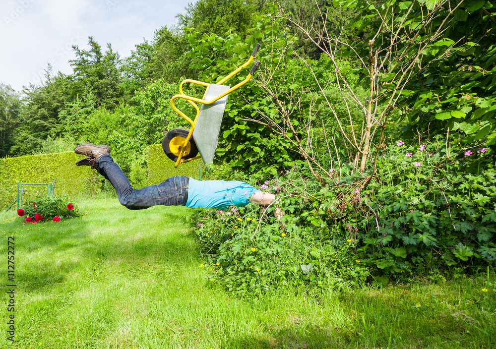 Wall mural Man flies with wheelbarrow in a bush.