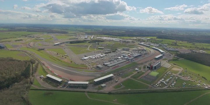 Aerial view of  a big  race on a sunny summer  day in England.  Cars going along the race. Full campsite.