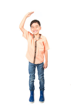 Little boy checking his height on white background