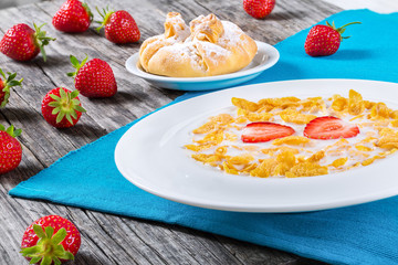 Corn flakes with milk and strawberries, close-up