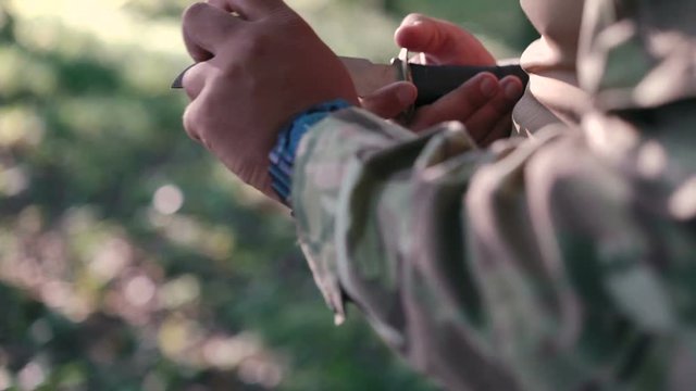 Close up of military sharpen knife with bilestone in the forest