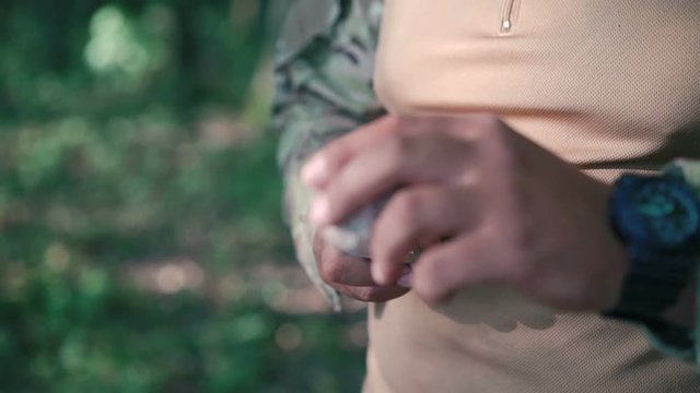 Close up of soldier sharpen knife with bilestone in the forest