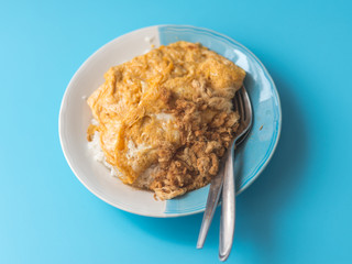 Thai-Style omlet on stream rice on blue background.
