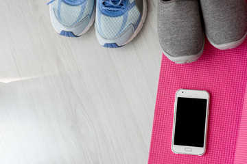 Blue,orange and black sport shoes with smartphone and yoga mat o