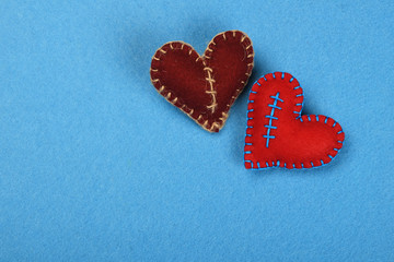 Two felt craft hearts, red and brown on blue