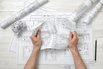 Close-up hands of architect tearing a bad drawing