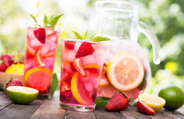 Pink lemonade with lemon, lime and strawberries 