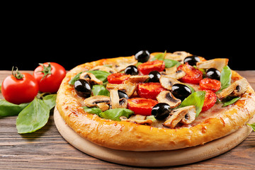 Delicious tasty pizza with ingredients on wooden table