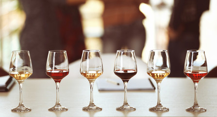 Many glasses of different wine in a row on a table. Tasting wine concept