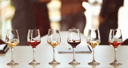 Foto op Plexiglas Veel glazen verschillende wijn op een rij op een tafel. Proeverij wijn concept © Africa Studio