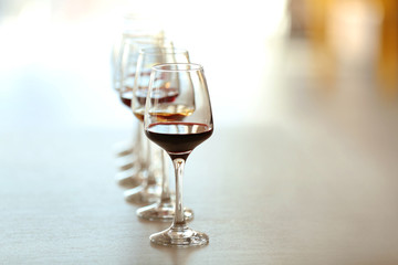 Many glasses of different wine in a row on a table