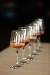 Many glasses of different wine in a row on a table