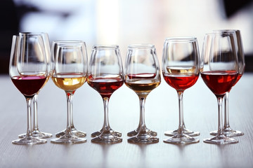 Many glasses of different wine in a row on a table