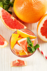 Fototapeta na wymiar Ripe grapefruits and fresh juice with mint, close up