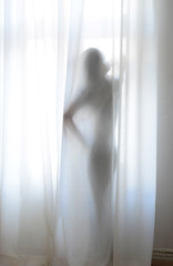 Frau hinter Vorhang am Fenster, Silhouette