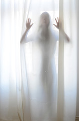 Frau hinter Vorhang am Fenster, Silhouette