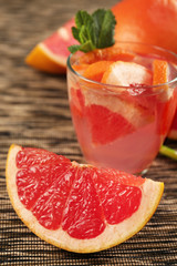 Ripe grapefruits and fresh juice with mint, close up