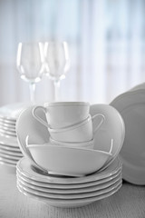 Set of new white dishes on wooden table, indoors