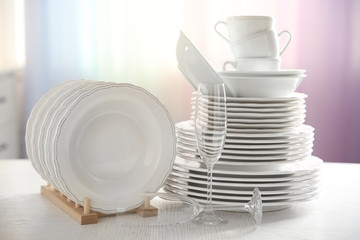 Set of new white dishes on wooden table, indoors