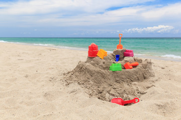 Fototapeta na wymiar Sand castle and kids toys on beach