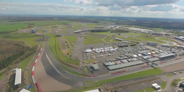 Aerial view of  a big  race on a sunny summer  day in England.  Cars going along the race. Full campsite.