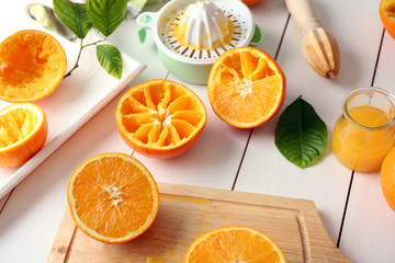 Juicing delicious oranges on white wooden table