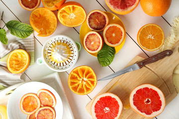 Juicing delicious oranges on white wooden table