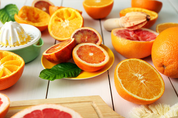 Juicing delicious oranges on white wooden table