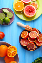 Juicing delicious citruses on blue wooden table