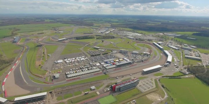 Aerial view of  a big  race on a sunny summer  day in England.  Cars going along the race. Full campsite.
