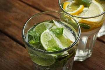Fresh cocktails with soda, lime, lemon on a wooden background