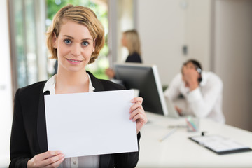 businesswoman holding blank sheet of paper in the office