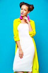 portrait of cheerful fashion hipster girl in casual colorful vivid hipster yellow summer clothes on blue background