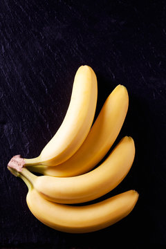 Bund Bananen, vier, gef&auml;chert. schwarzer Untergrund, Schiefer,