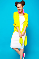 portrait of cheerful fashion hipster girl in casual colorful vivid hipster yellow summer clothes on blue background
