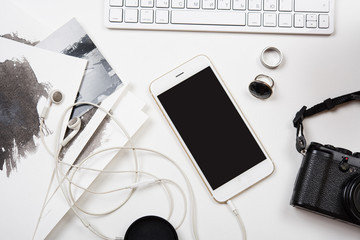 Modern smartphone, computer keyboard and photo camera on white t