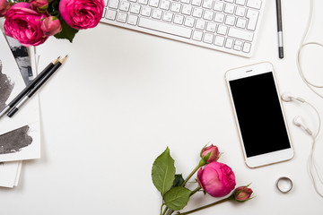smartphone, computer keyboard and fesh pink flowers on white tab