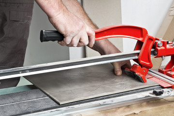 Home improvement, - close-up of handyman laying tile