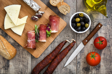 Spanish serrano ham, cheese and sausage on a rustic wooden background
