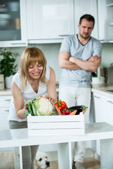 Mann und Frau mit Gemüsekiste in der Küche
