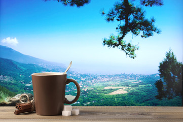 Coffee cup against mountain landscape