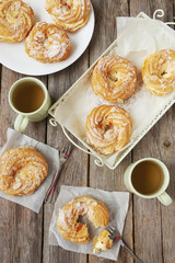 Sweet eclairs on a grey wooden table