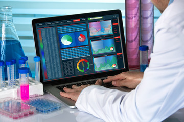biomedical engineering working with computer in laboratory / scientist working with laptop in lab
