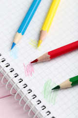 Drawing colourful pencils with notebook on a wooden background
