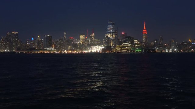 New York city skyline at night. City lights reflects on the water. Manhattan New York City