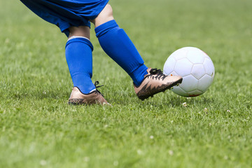close up of children that kicks the ball